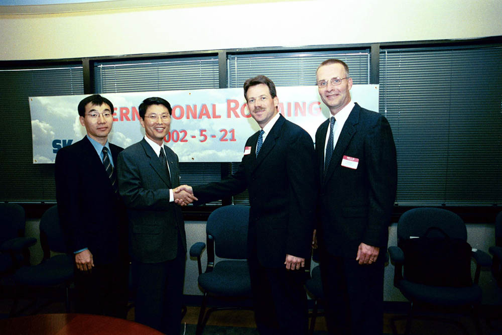 At the ceremony for the Korea-USA Automatic Roaming Service Launch, Il Won Lim (on left),and Tony Melone are shown shown shaking hands.